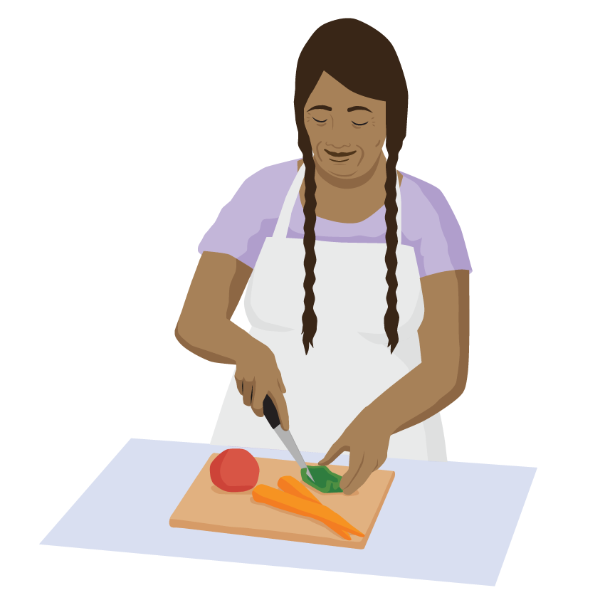 A person is standing, chopping vegetables